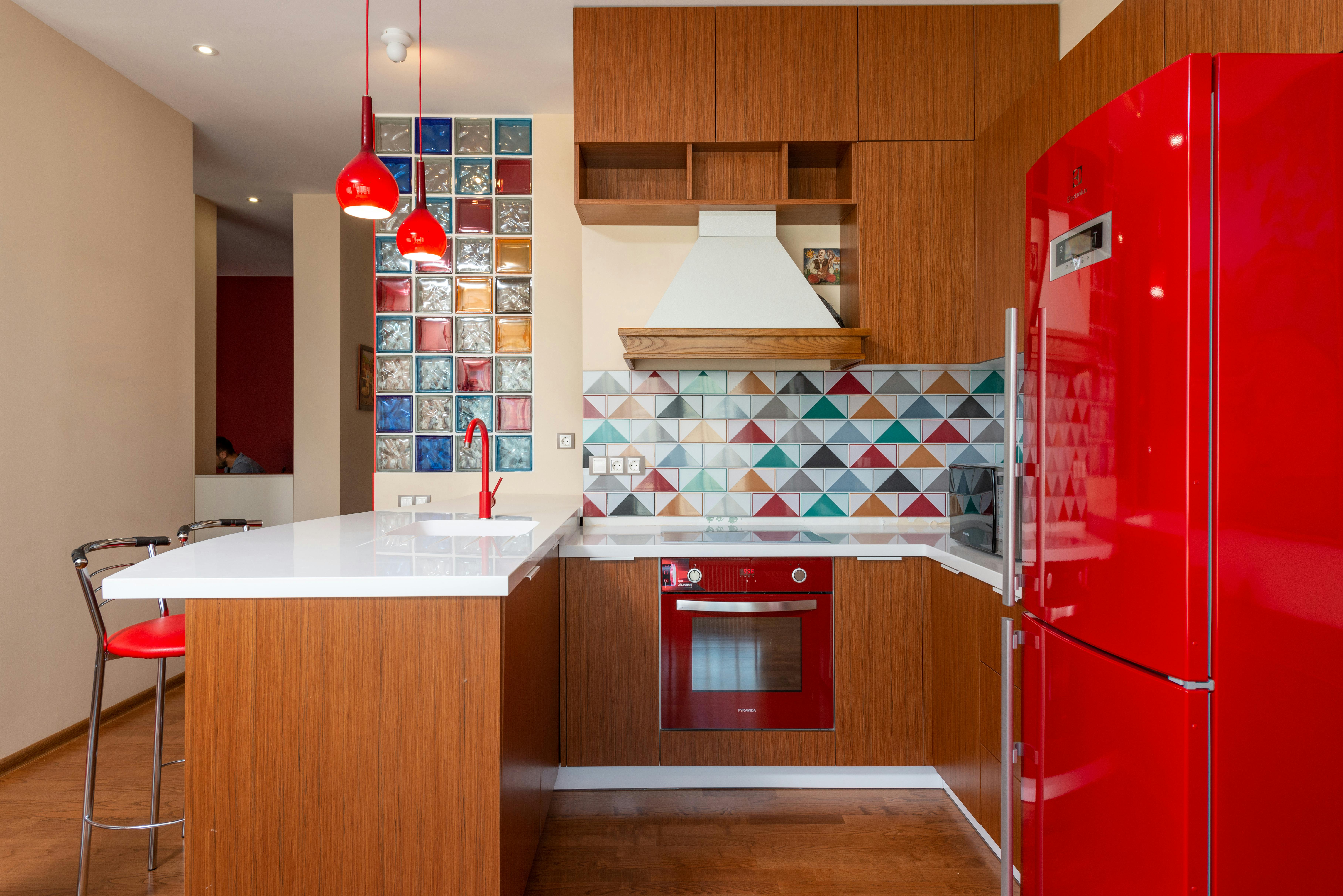 Stylish modern kitchen with red accents and contemporary design elements.