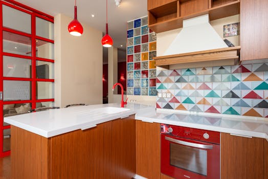 Contemporary kitchen featuring a multicolored geometric backsplash and red accents.