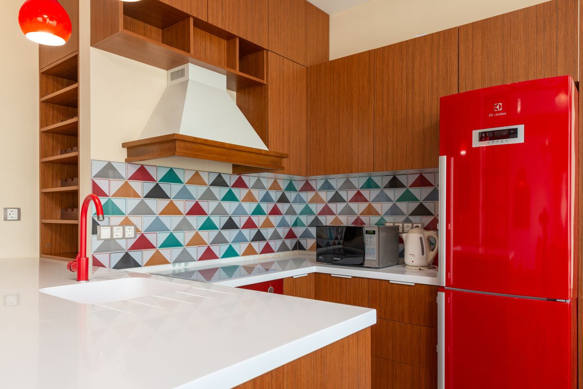 Kitchen interior with colorful tile and a red refrigerator