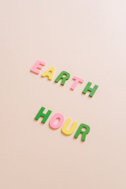 Free Colorful letters spelling 'Earth Hour' on a beige background, promoting eco-awareness. Stock Photo