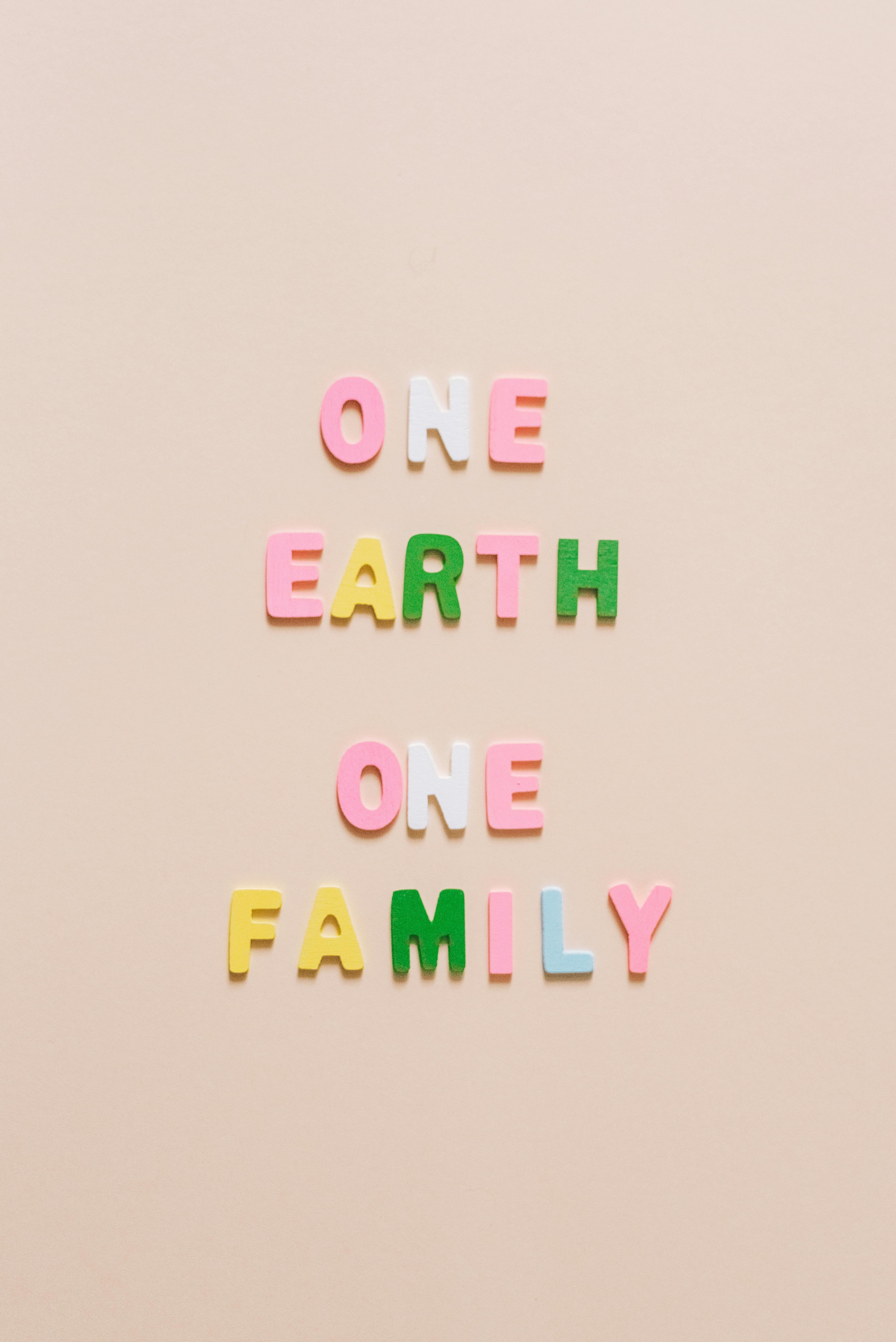 one earth one family lettering on a white surface