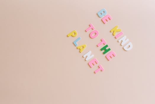 Colorful text on beige background promoting environmental awareness with 'Be Kind to the Planet'.