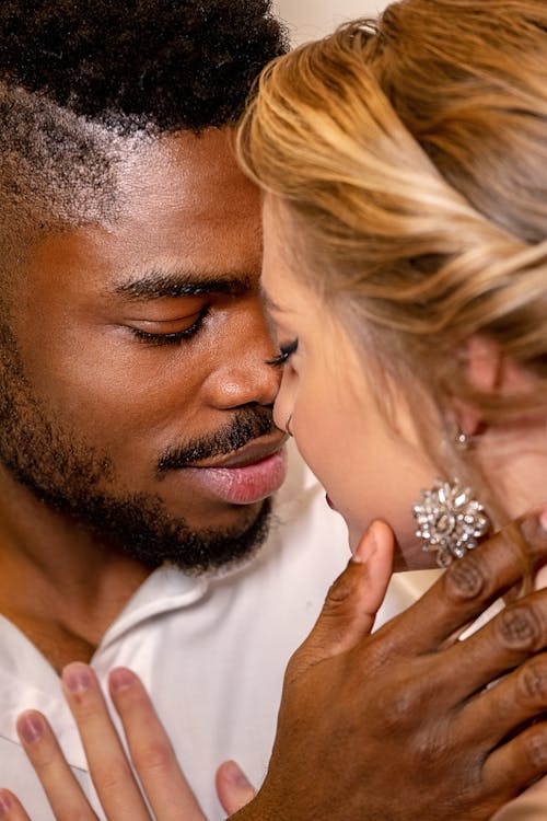 Free Man in White Polo Kissing a Woman while Holding her Neck Stock Photo