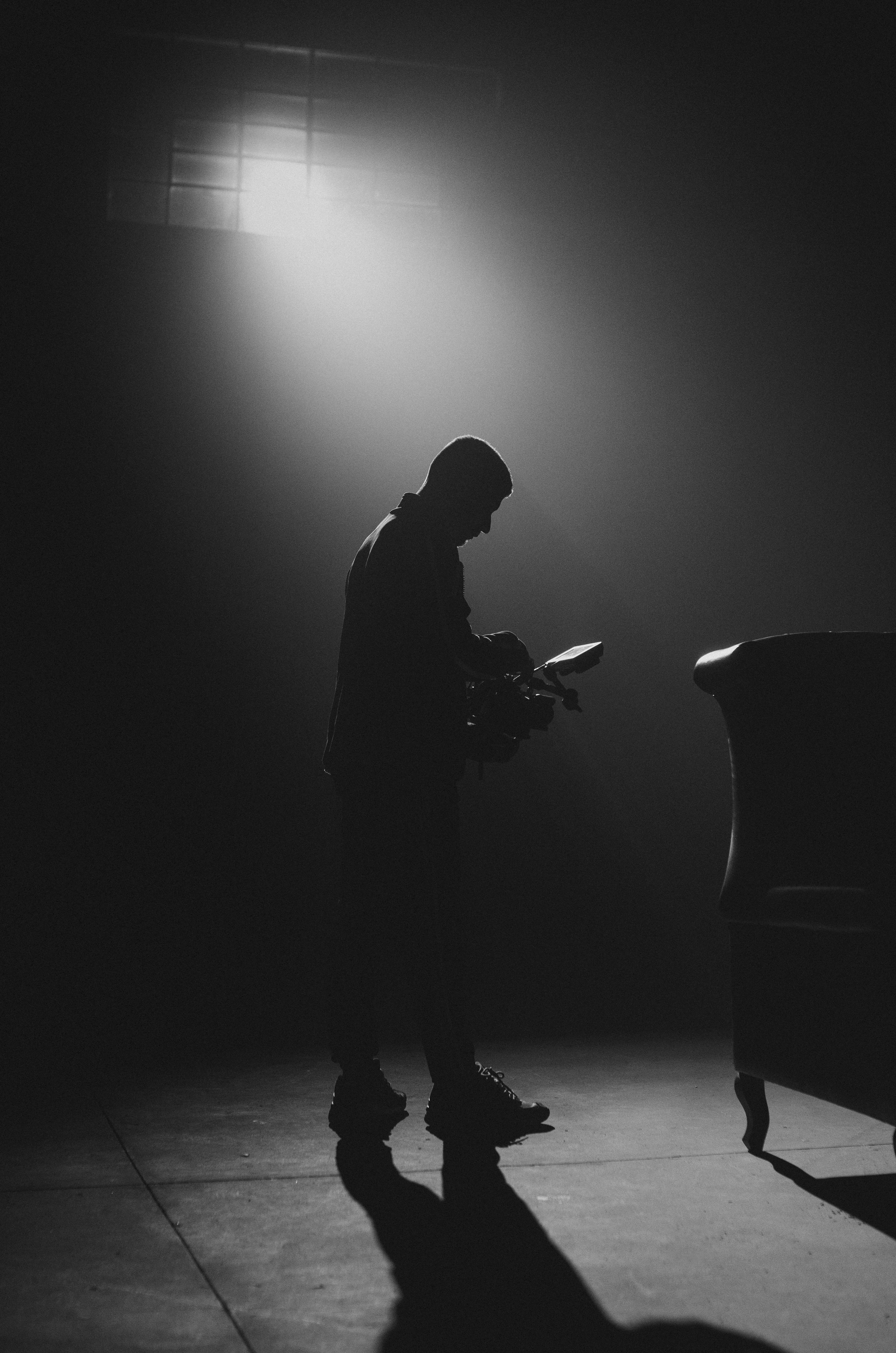 a silhouette of a man using a camera