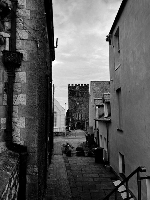 Black and white narrow pedestrian street between old residential buildings in historic town district