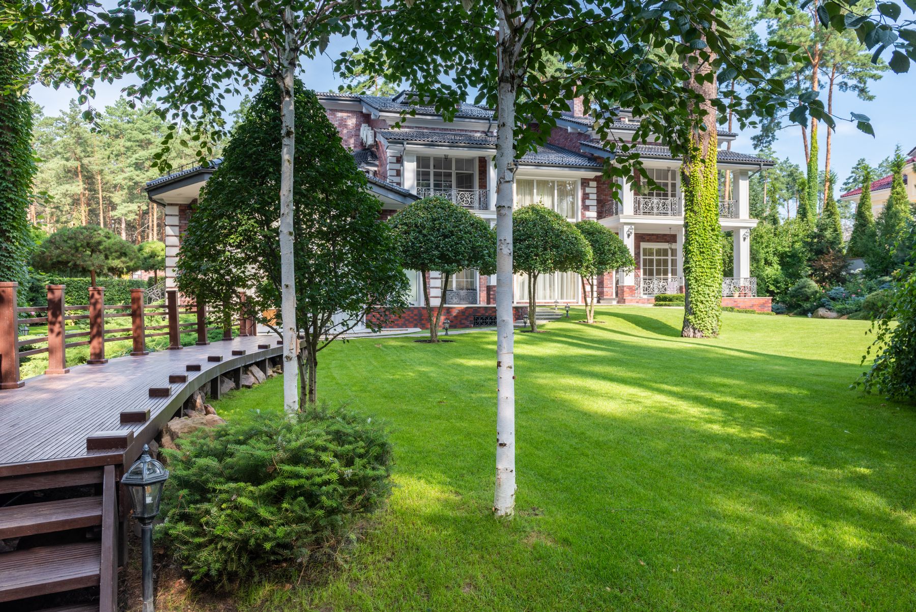 A lawn and trees in front of a large house