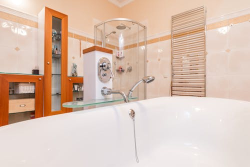 White Ceramic Bathtub With Stainless Steel Faucet in the Bathroom