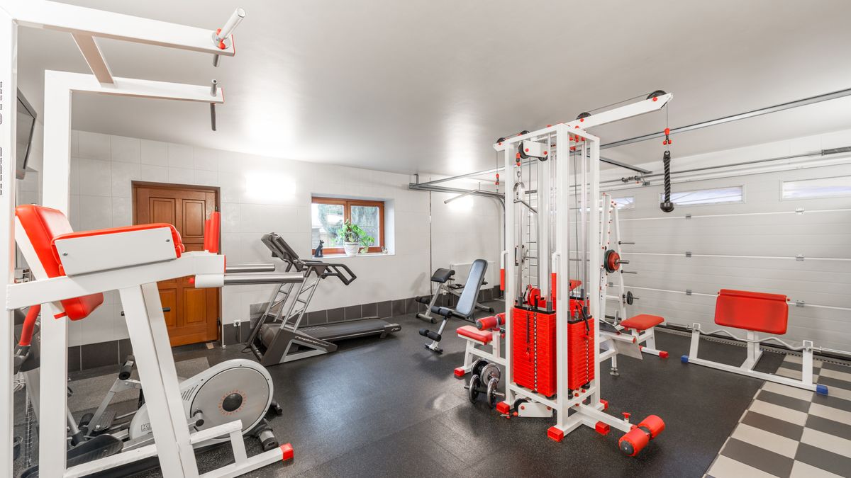 Modern interior design of new spacious fitness gym for home sport training and heavy weightlifting in garage of big house