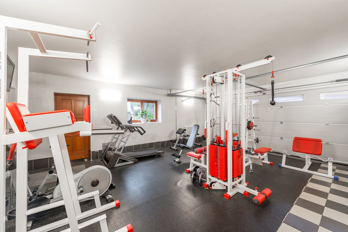 Free Modern interior design of new spacious fitness gym for home sport training and heavy weightlifting in garage of big house Stock Photo