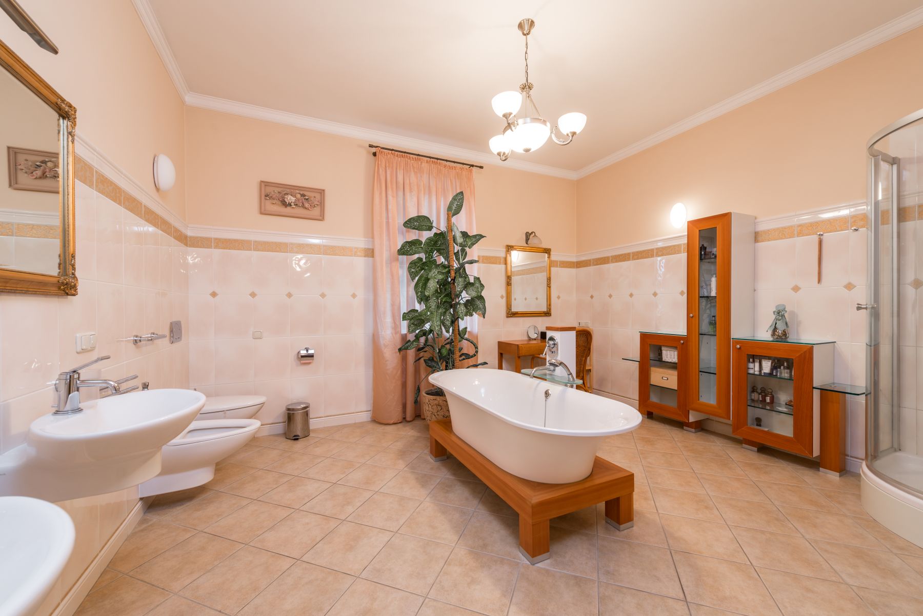 Spacious traditional bathroom with freestanding tub, framed vanity furniture and a soft neutral palette