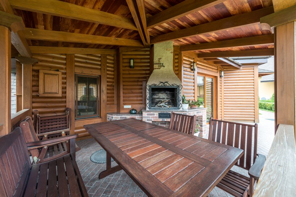 Timber pergola with table and benches beside the house