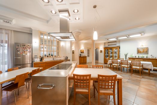Staf dapur sedang bekerja di bawah sistem ventilasi stainless steel