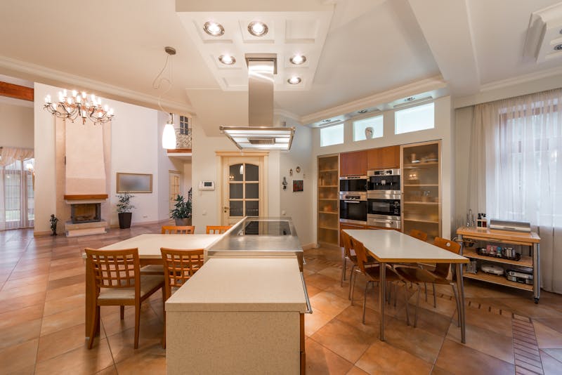 A home office with a wooden easel and a large curved monitor