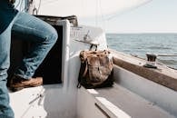 Person in Blue Denim Jeans Sitting on Boat