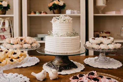 Wedding cake with floral decor between treats on table