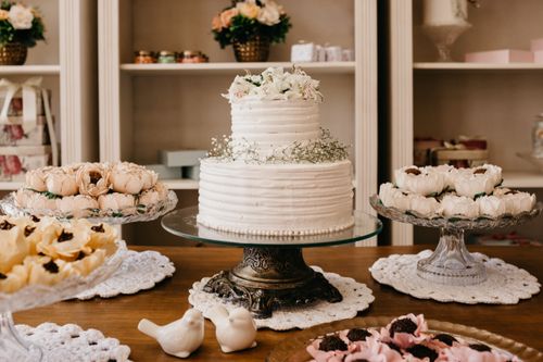 Free Delicious cake decorated with flowers on stand between assorted chocolate truffles on desk during festive event Stock Photo