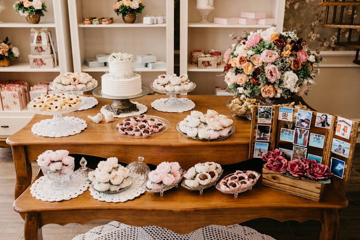 Assorted sweets on table with blooming flowers on wedding day