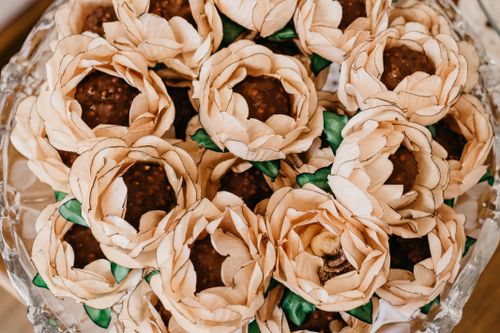 Free Top view of tasty chocolate balls in decorative paper flowers with wavy petals on plate during festive event Stock Photo
