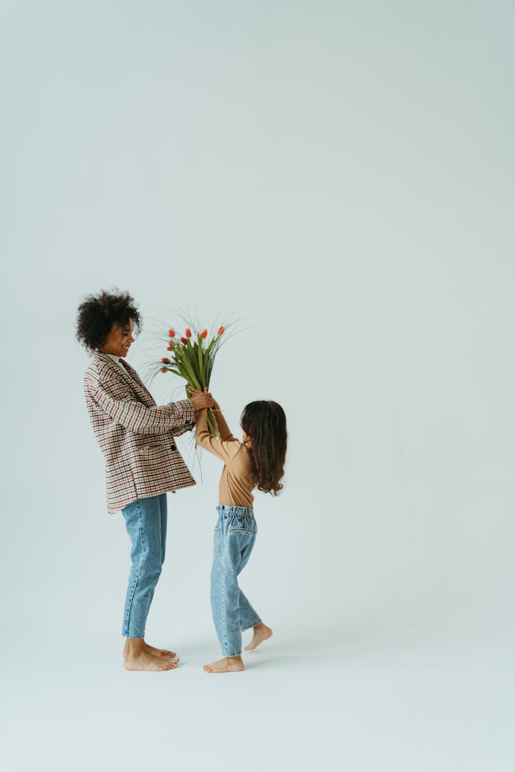 A Girl Giving Her Mother A Bunch Of Flowers