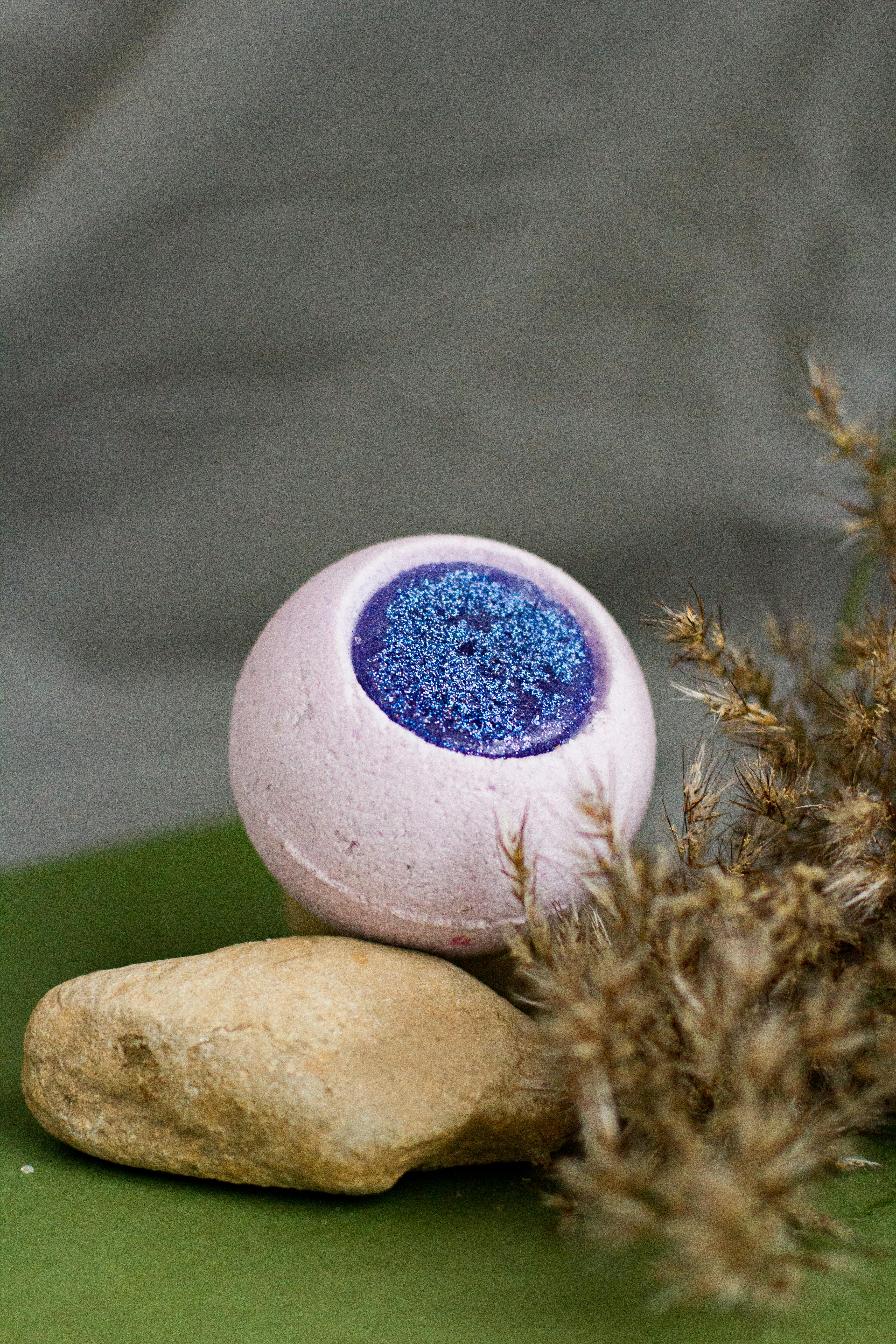 bath bomb and stone arranged on green table