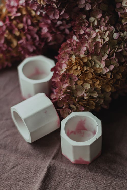 White candleholders placed near dark red flowers