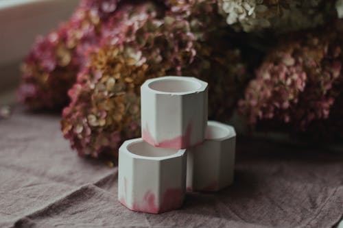 Free High angle of plaster candle holders placed near bunch of blooming hydrangea flowers on table Stock Photo