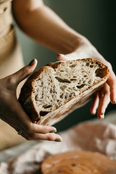 From above of crop anonymous female demonstrating delicious freshly baked sourdough bread in kitchen