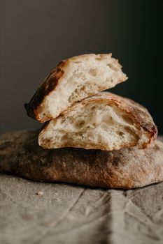 Pieces of soft bread with crispy crust placed on gray cloth in bakery