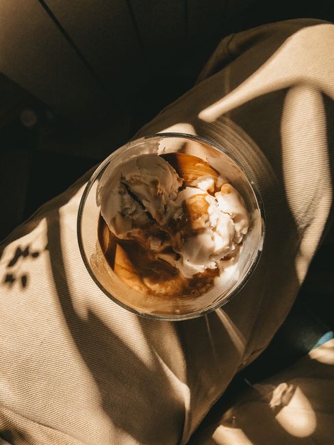 Top view of sugary cream in glass bowl placed on fabric in sunshine