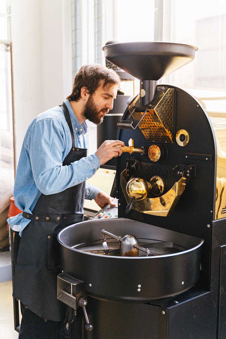 A Man Using A Coffee Roaster