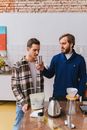 Man in Blue Sweater Holding Silver Iphone 6