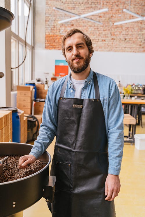Free Photo of a Man in a Blue Long Sleeve Shirt Wearing a Black Apron Stock Photo