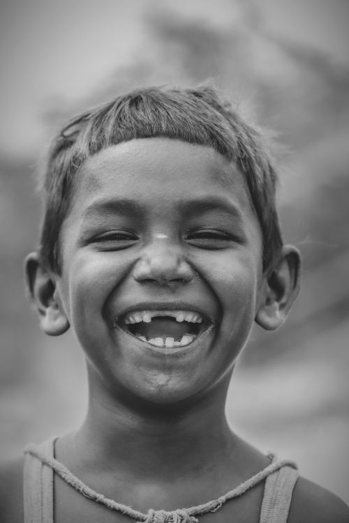 Free A black-and-white portrait of a laughing child, showcasing pure joy. Stock Photo