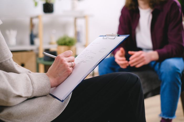 Close-up of a coach writing notes during a client session