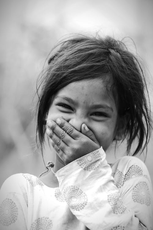 Free Monochrome Photo of a Girl Laughing while Covering Her Mouth Stock Photo