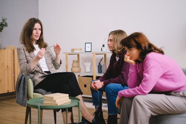 Teacher In A Checked Suit In A Room With Two Students