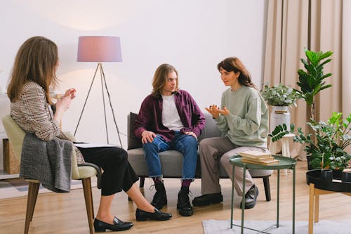 Couple talking with psychologist in light room