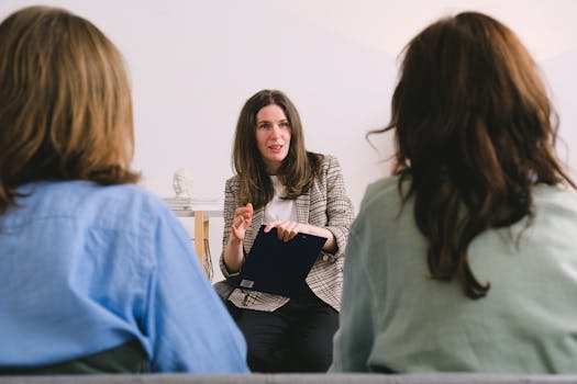 Therapist engaging in a conversation with two clients during a counseling session.