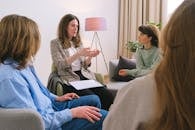 Mental female specialist speaking to group of clients
