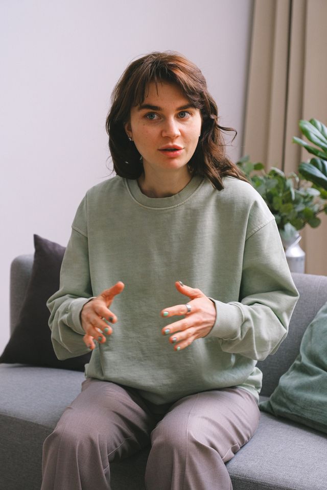 Creator mid-sentence, talking to camera from her sofa — photo by SHVETS production on Pexels