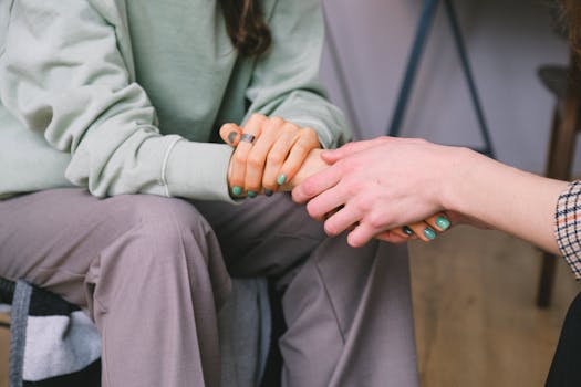 the hand of a psychologist is seen supporting a patient during counseling