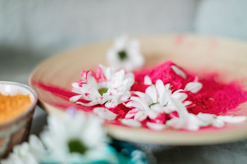 Selective Focus of White Flowers and Holi Powder on Ceramic Plate