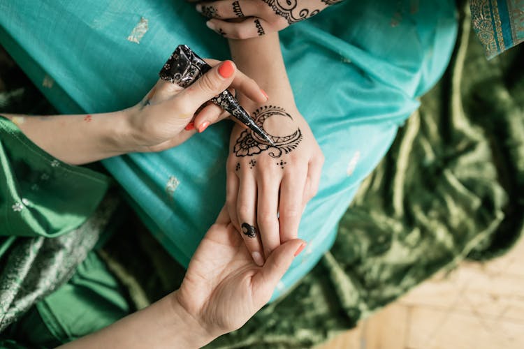 A Person Doing Mehndi On Hand