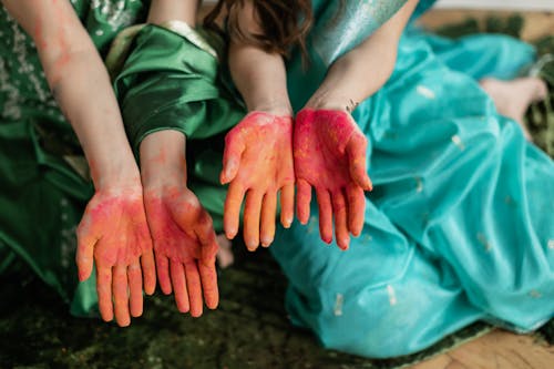 Two Women Showing Palms in Red Holi Powder