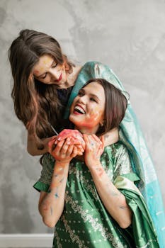 Two women celebrating Holi with vibrant colors and joyful expressions, embodying happiness and cultural richness.