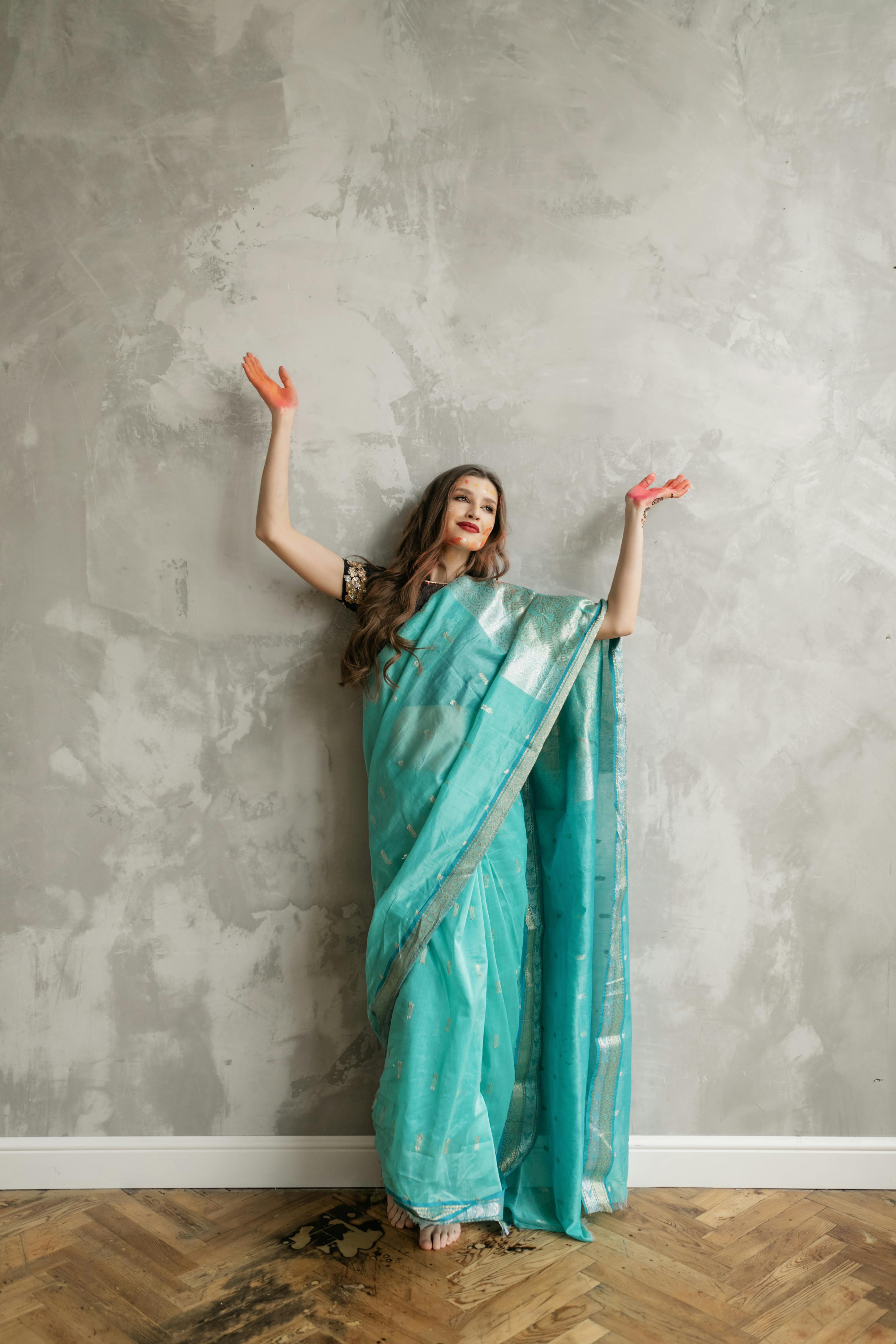 Woman in Green Sleeveless Dress Standing Beside White Wall