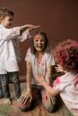 Woman in White Button Up Shirt Standing Beside Girl in Pink Shirt