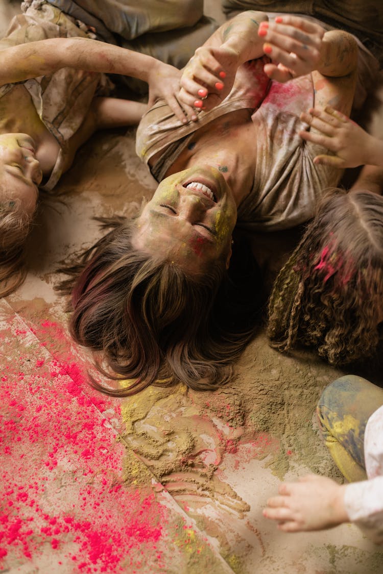 Photo Of A Woman And Kids Lying On Holi Powder