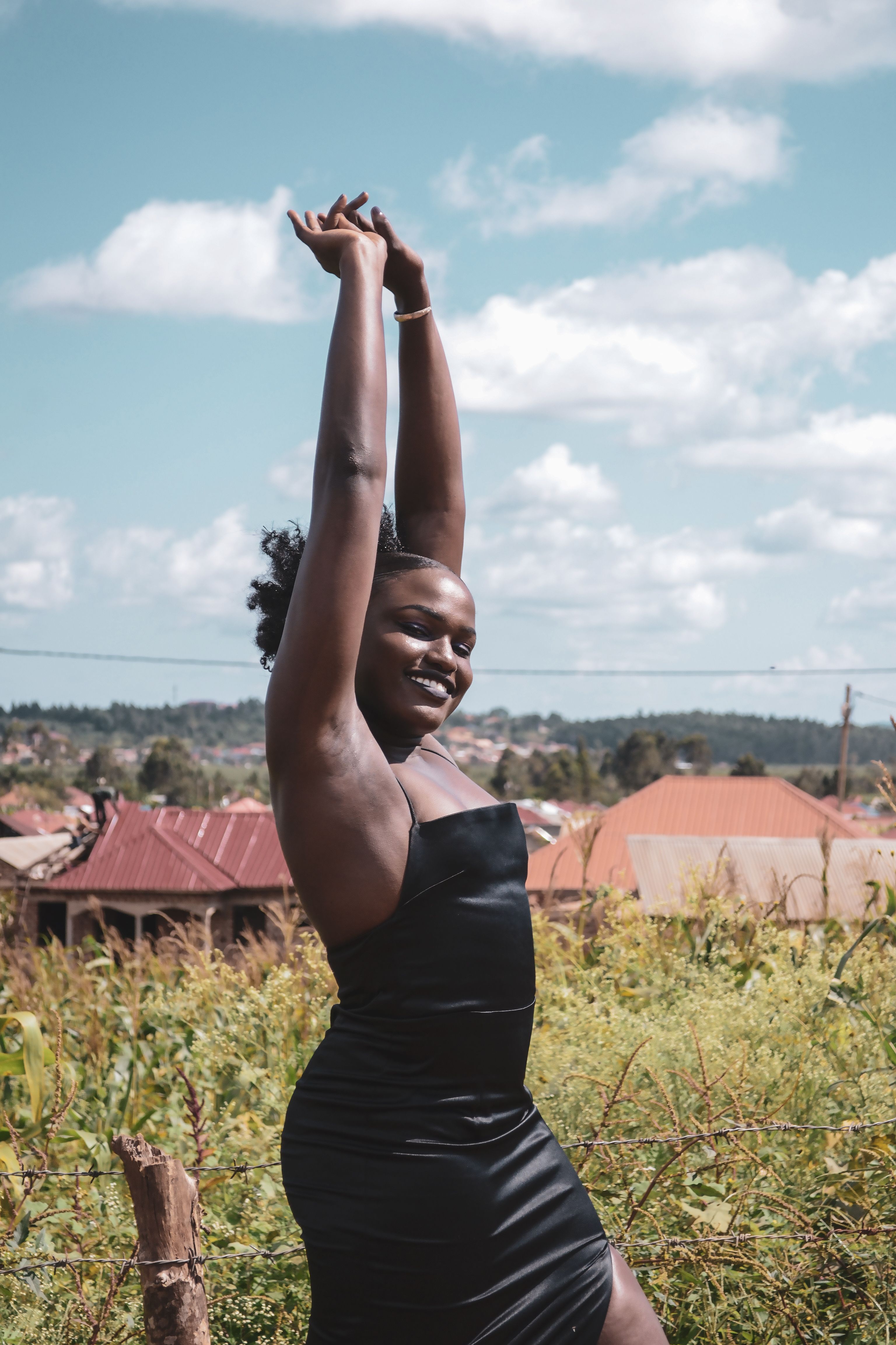 A Woman Wearing a Black Dress Posing with Her Hands Up · Free Stock Photo