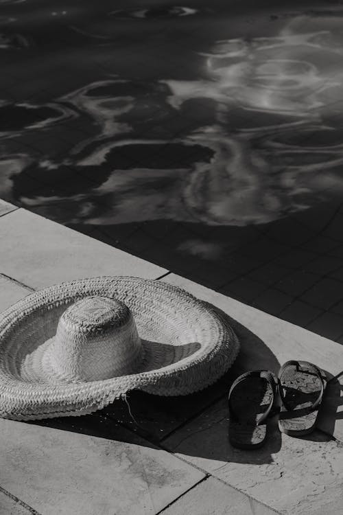 Free Grayscale Photo of a Sun Hat on the Poolside Stock Photo